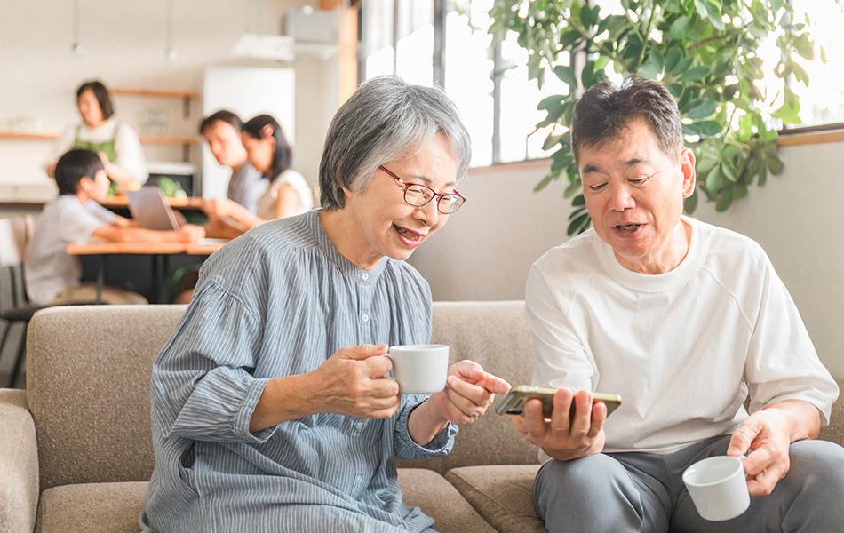 スマホを見ている老夫婦の写真